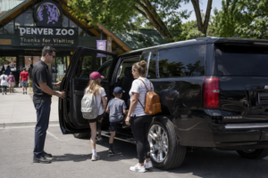 family with kids getting into a comfortable SUV outside the Denver Zoo entrance suburb